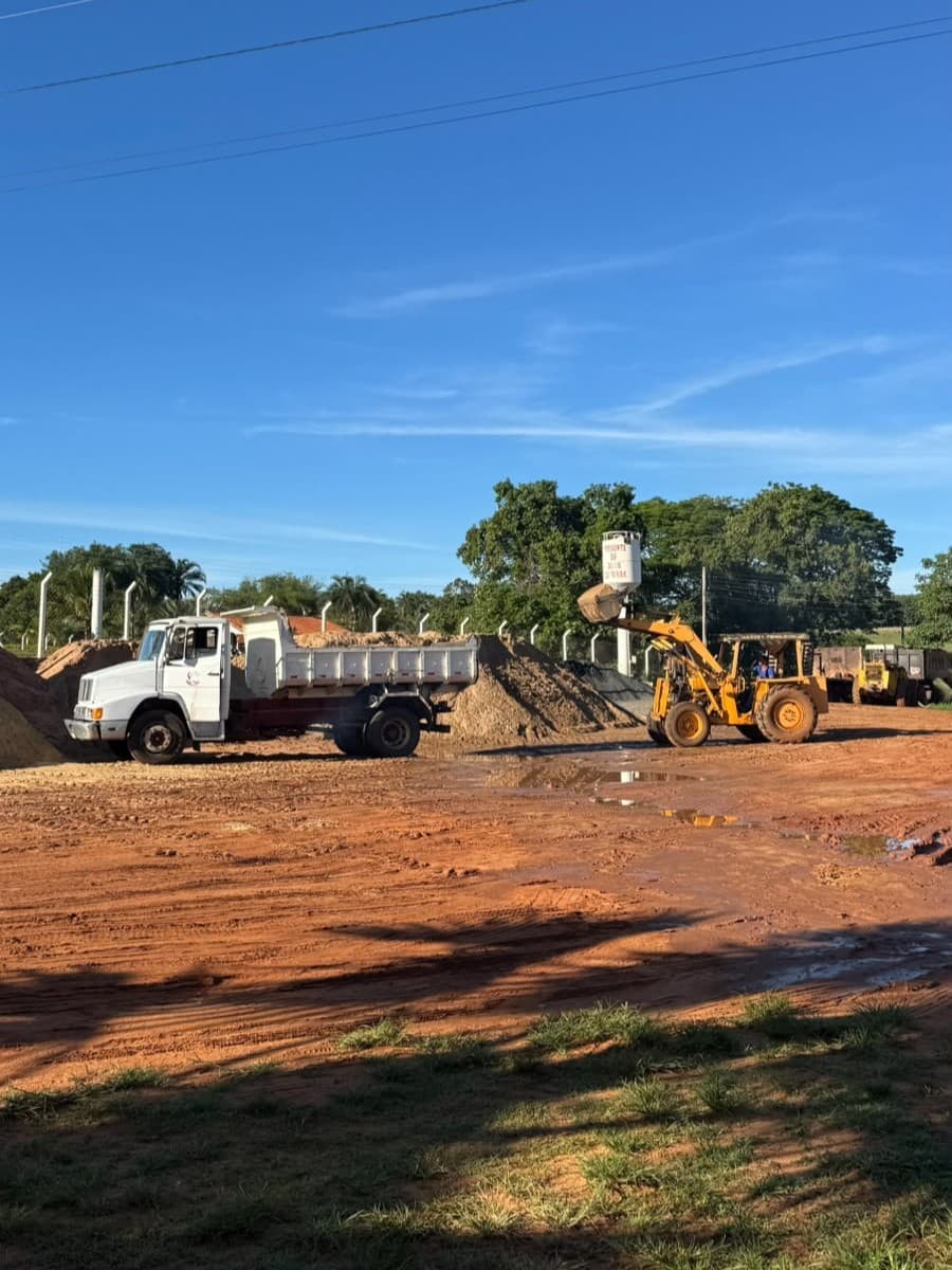Pá carregadeira carregando brita no pátio
